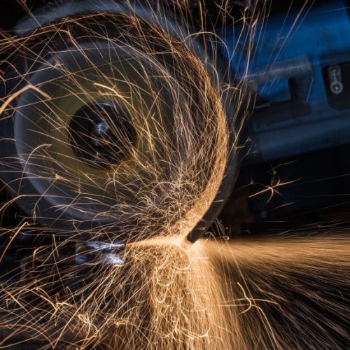 Worker cutting metal with grinder